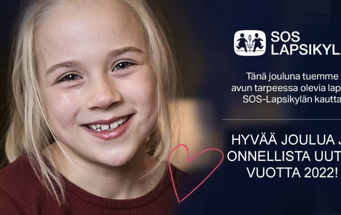 Hymyilevä tyttö puhelin kädessään.