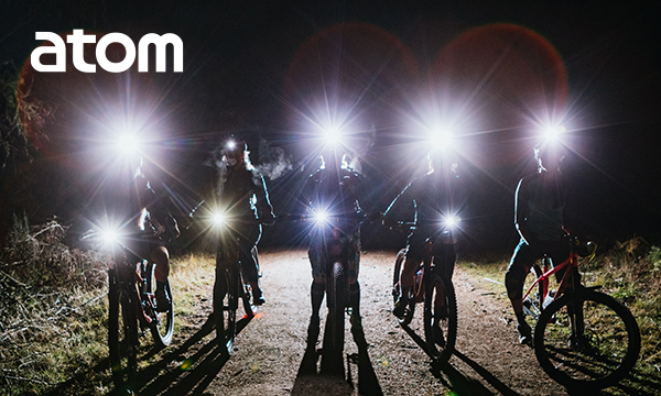 Bicyles and cyclists in the dark with head lamps.